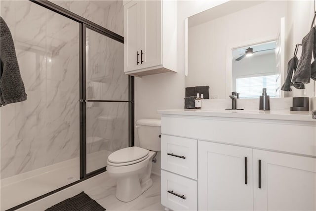 bathroom featuring a shower with door, vanity, and toilet