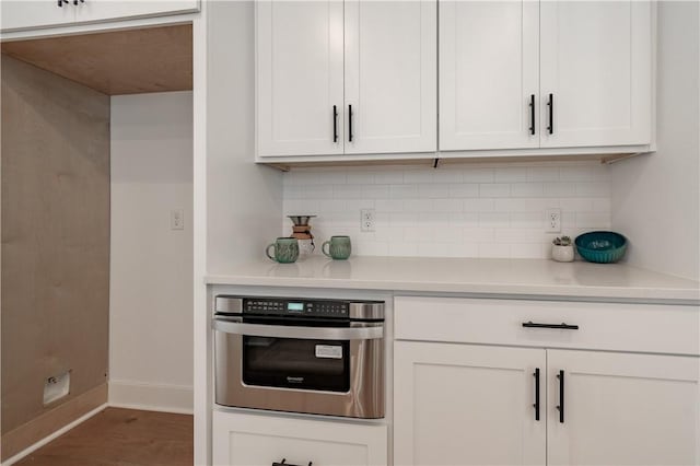 427 E Martin Luther King Jr Blvd, Fayetteville, AR 72701 - kitchen featuring oven, decorative backsplash, light countertops, and white cabinets
