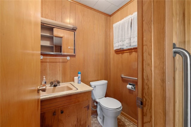 bathroom with vanity, toilet, crown molding, and wood walls