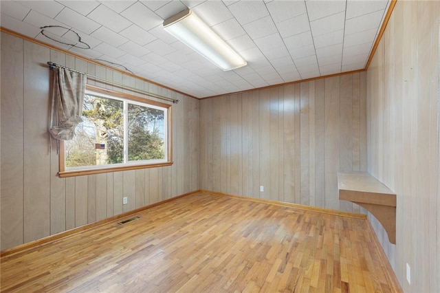 empty room featuring crown molding and hardwood / wood-style flooring