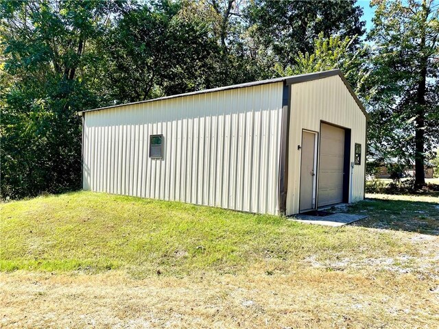 view of outdoor structure featuring a garage and a lawn