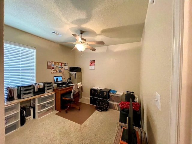 carpeted office featuring ceiling fan and a textured ceiling