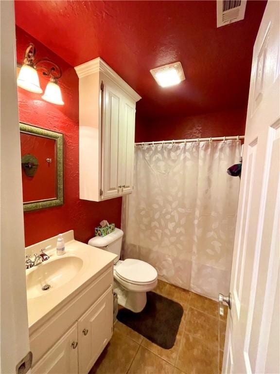 bathroom featuring tile patterned flooring, vanity, and toilet