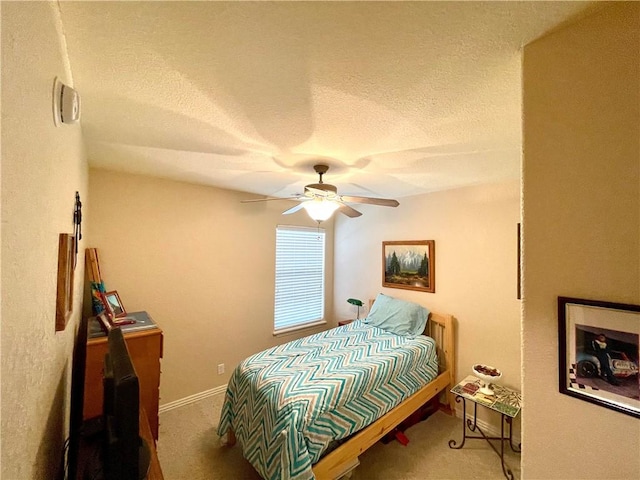 bedroom featuring carpet flooring, a textured ceiling, and ceiling fan