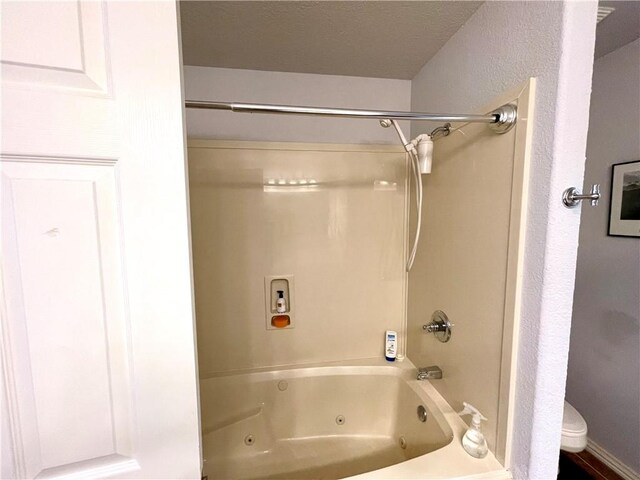 bathroom featuring toilet and bathing tub / shower combination