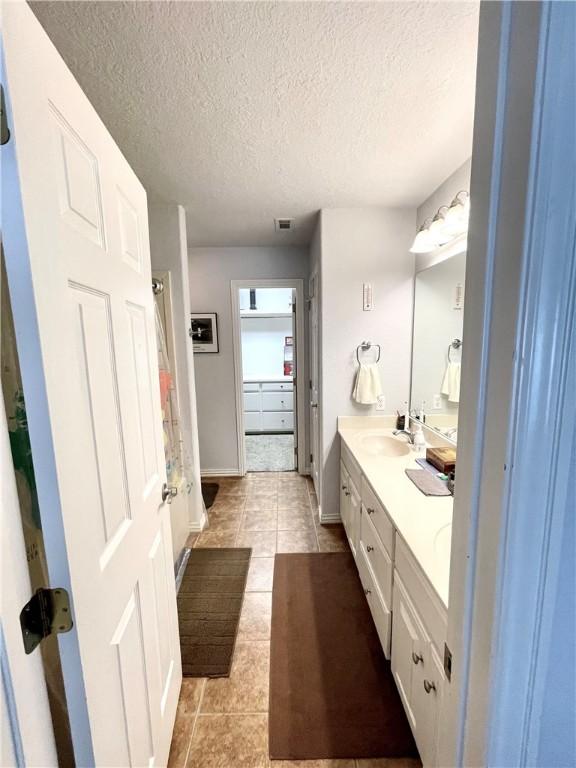 bathroom with vanity, tile patterned floors, and a textured ceiling