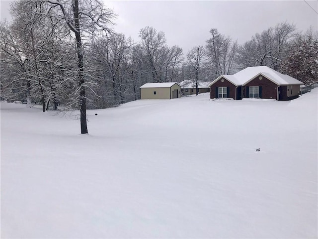 snowy yard featuring an outbuilding and a garage