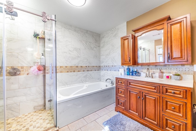 bathroom with vanity, independent shower and bath, tile walls, and tile patterned floors