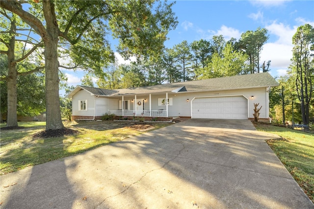 view of front of house with a garage, a front lawn, and covered porch