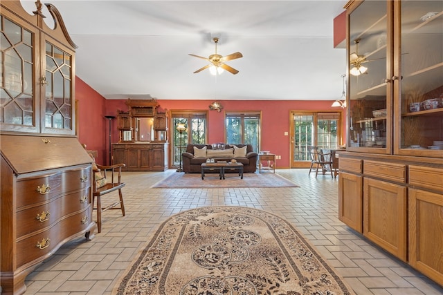 living room featuring ceiling fan, plenty of natural light, and vaulted ceiling