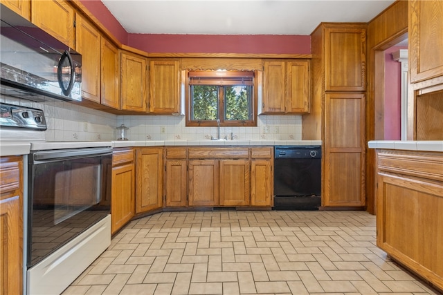 kitchen featuring black appliances, sink, tile countertops, and backsplash