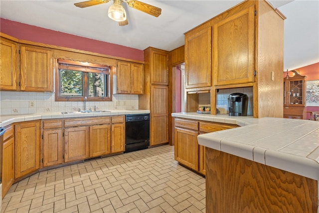 kitchen with tile counters, decorative backsplash, sink, and dishwasher