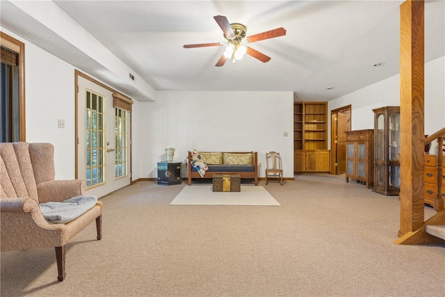 living area featuring ceiling fan and light colored carpet