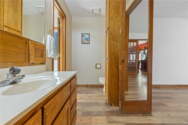 bathroom featuring hardwood / wood-style flooring, vanity, and toilet