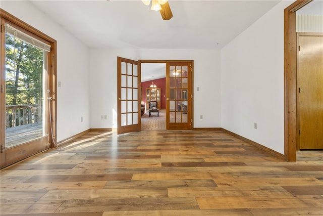 unfurnished room with french doors, hardwood / wood-style flooring, vaulted ceiling, and ceiling fan