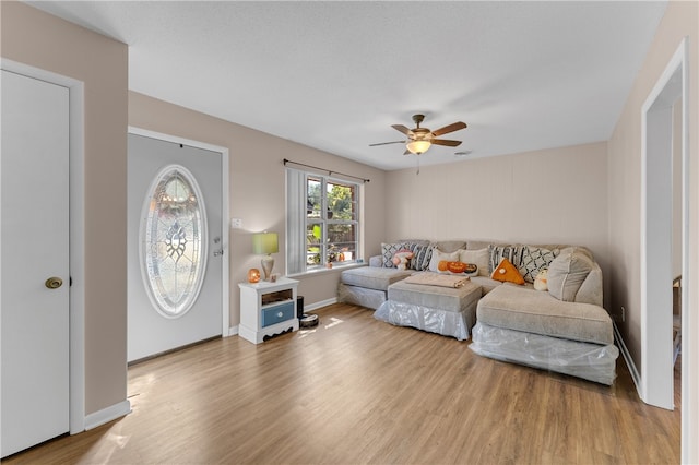 living room with wood-type flooring and ceiling fan