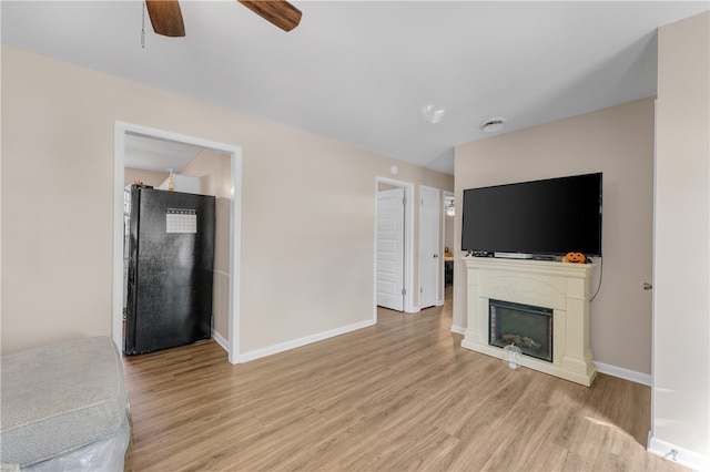 unfurnished living room featuring ceiling fan and light hardwood / wood-style flooring