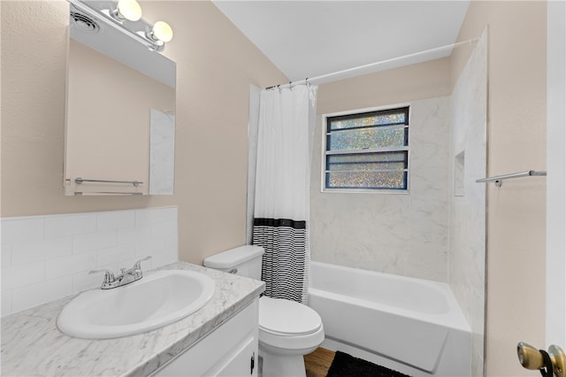 full bathroom featuring hardwood / wood-style flooring, decorative backsplash, shower / tub combo with curtain, vanity, and toilet