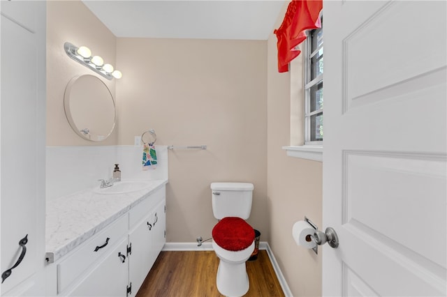 bathroom with hardwood / wood-style floors, vanity, and toilet