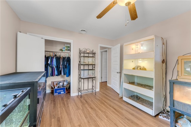 bedroom with light hardwood / wood-style floors, ceiling fan, and a closet