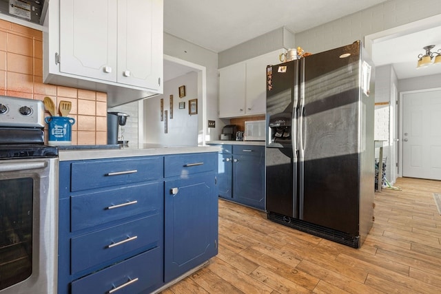 kitchen featuring appliances with stainless steel finishes, blue cabinets, white cabinetry, and light hardwood / wood-style floors