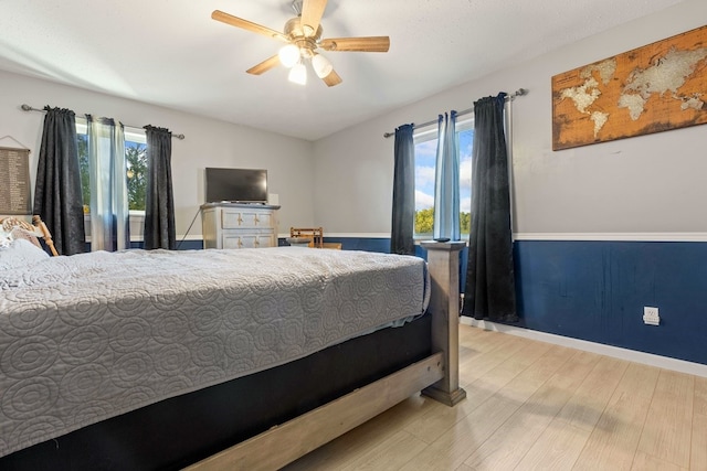 bedroom with light wood-type flooring, ceiling fan, and multiple windows