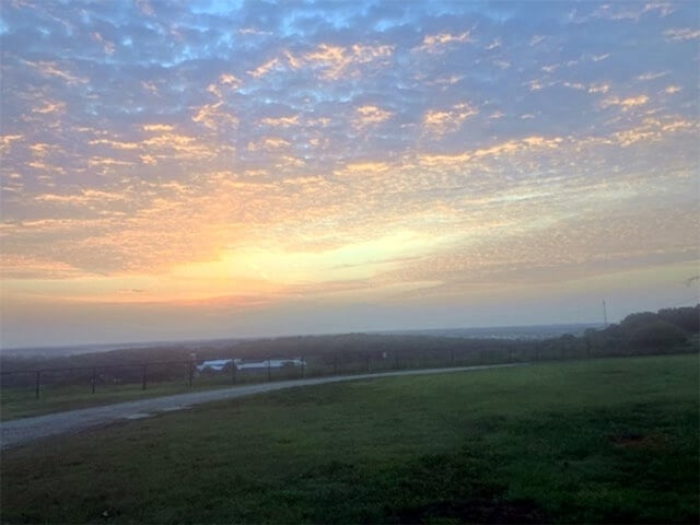 yard at dusk with a rural view