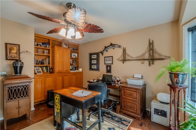 home office with dark hardwood / wood-style flooring and ceiling fan