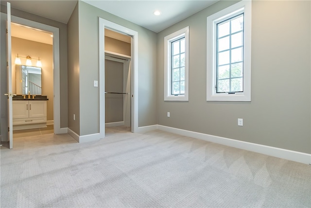 unfurnished bedroom with light carpet and ensuite bathroom