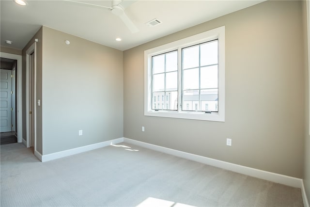 empty room featuring ceiling fan and light carpet