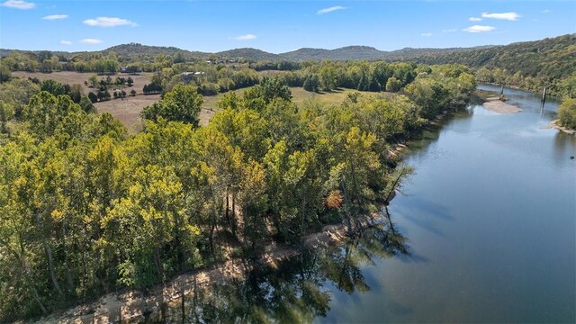 drone / aerial view featuring a wooded view and a water and mountain view