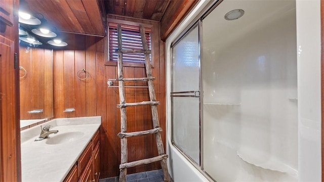 full bathroom featuring shower / bath combination with glass door, wooden walls, vanity, and wood ceiling