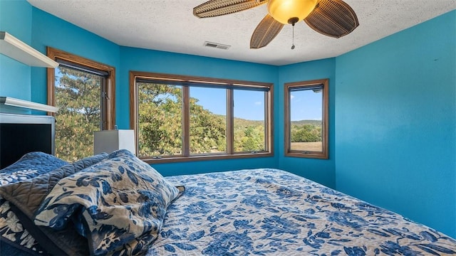 unfurnished bedroom featuring visible vents, ceiling fan, and a textured ceiling