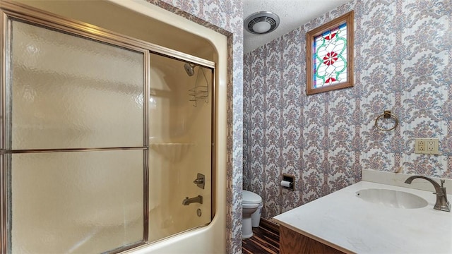 full bathroom featuring a textured ceiling, visible vents, toilet, combined bath / shower with glass door, and wallpapered walls