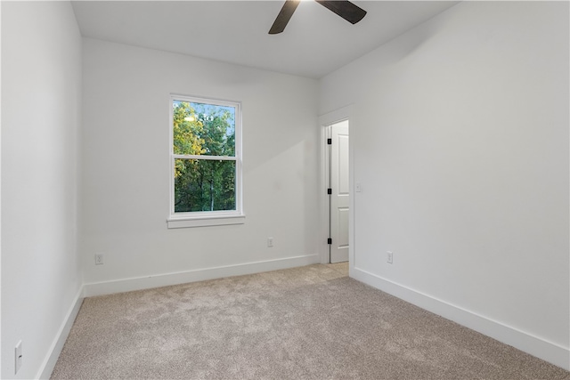 spare room featuring light carpet and ceiling fan