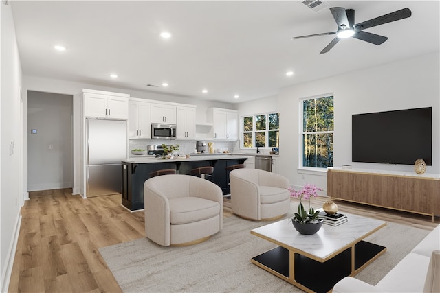 living room featuring ceiling fan and light wood-type flooring