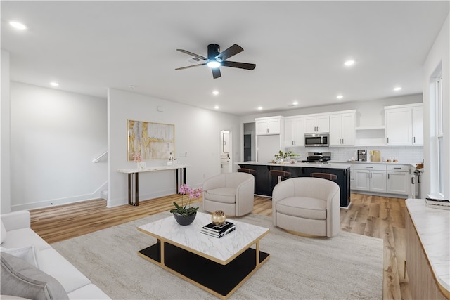 living room featuring ceiling fan and light wood-type flooring