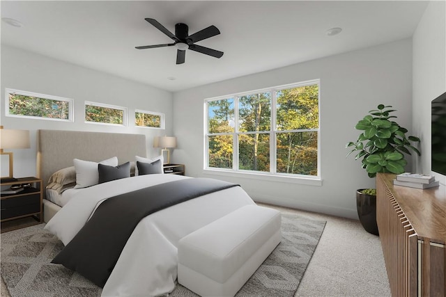 carpeted bedroom featuring multiple windows and ceiling fan