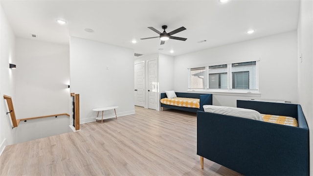 living room with ceiling fan and light hardwood / wood-style flooring