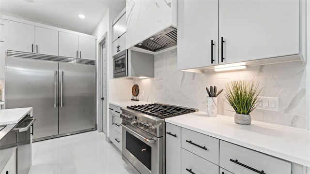 kitchen featuring decorative backsplash, white cabinetry, built in appliances, and custom exhaust hood