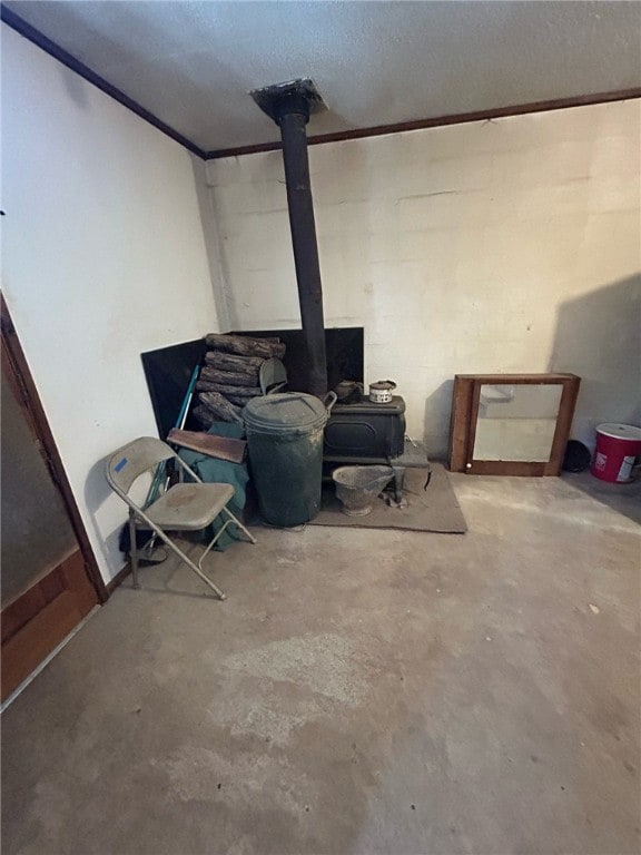 basement with a textured ceiling and a wood stove