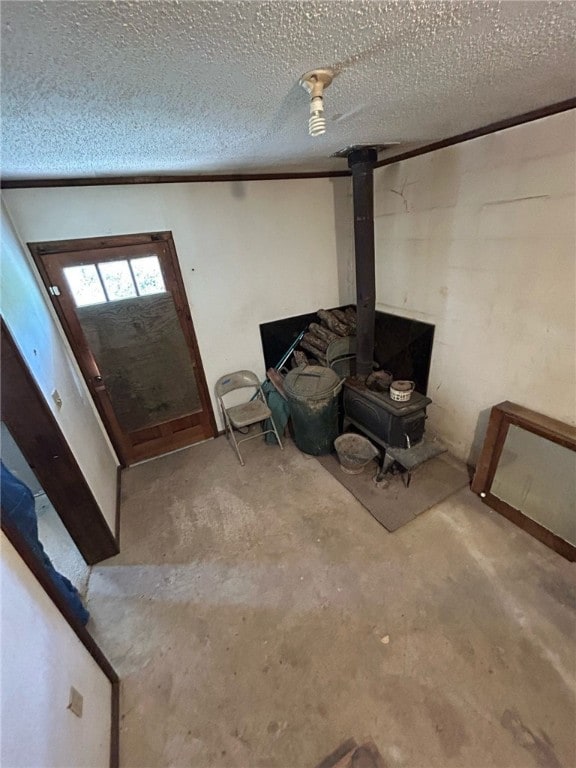 basement with a textured ceiling and a wood stove