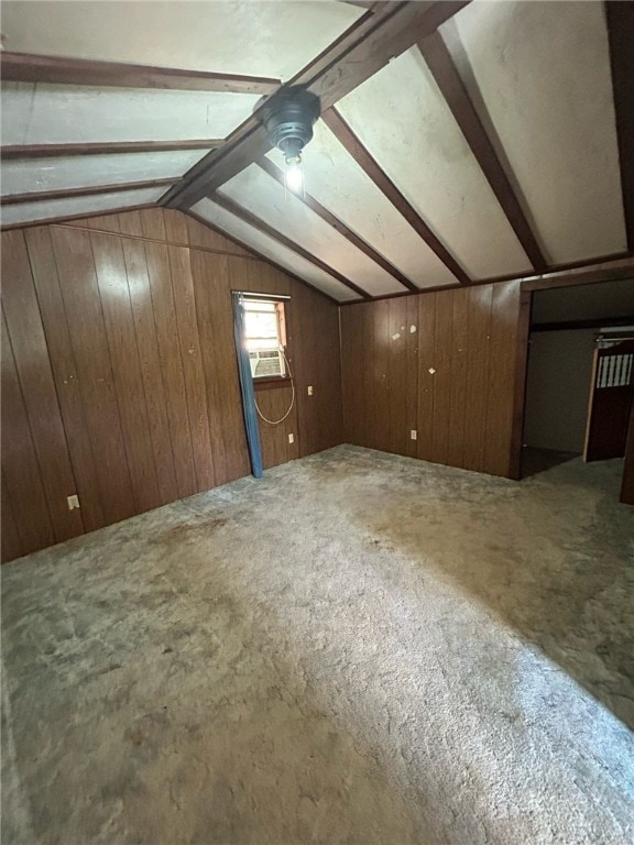 bonus room with wood walls, carpet flooring, and lofted ceiling with beams