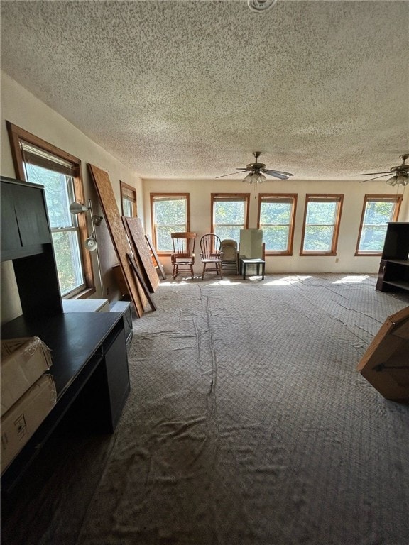 bedroom with ceiling fan, carpet flooring, and a textured ceiling