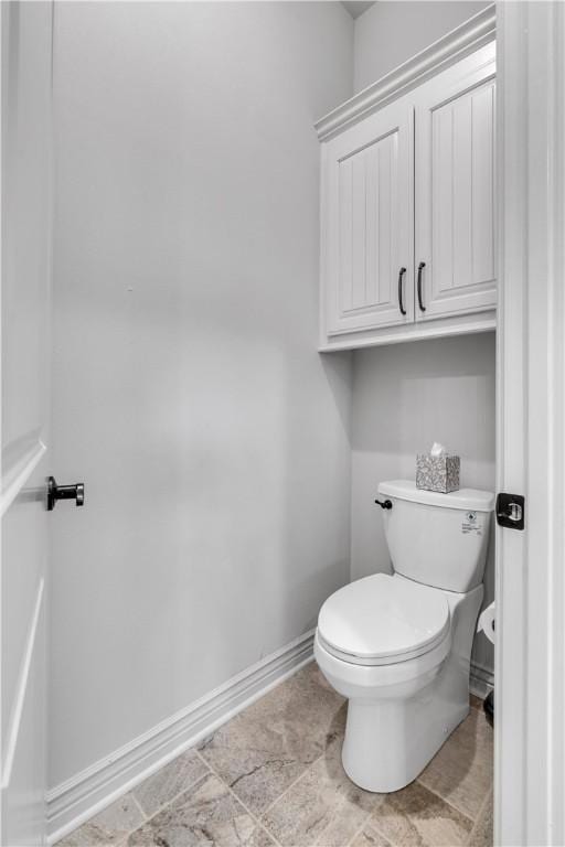 bathroom with baseboards and toilet
