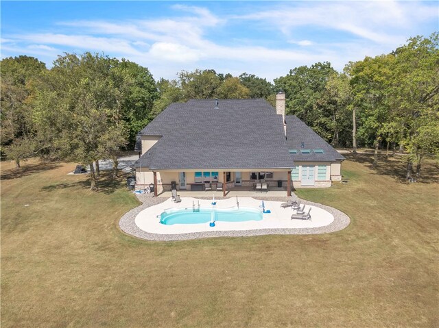 outdoor pool with a yard and a patio area