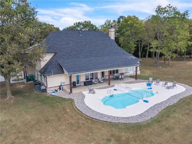 view of pool with a lawn and a patio