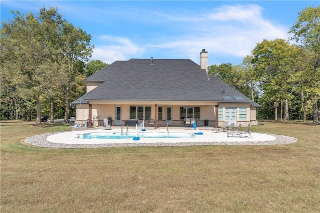 back of property featuring a patio, stucco siding, a chimney, an outdoor pool, and a lawn