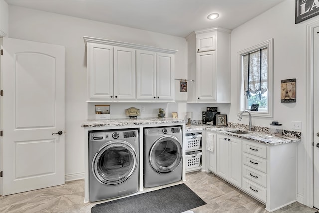 washroom with cabinets, sink, and washing machine and clothes dryer