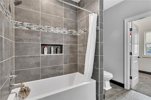 bathroom with shower / bath combo, tile patterned floors, baseboards, and toilet